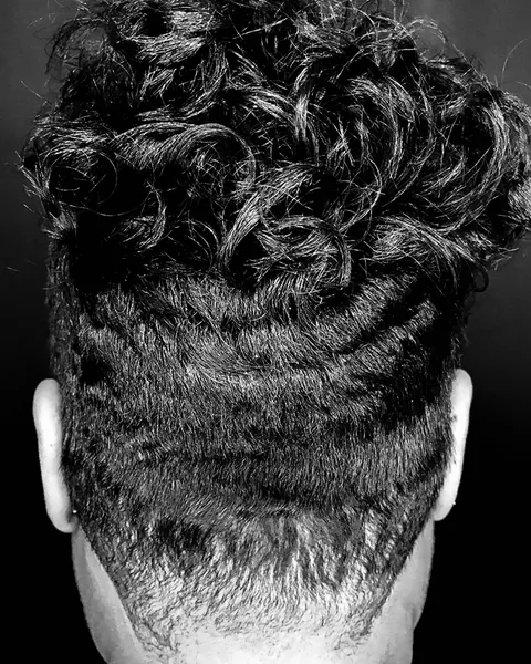 Back view of a short cut with sculpted texture and a tapered nape